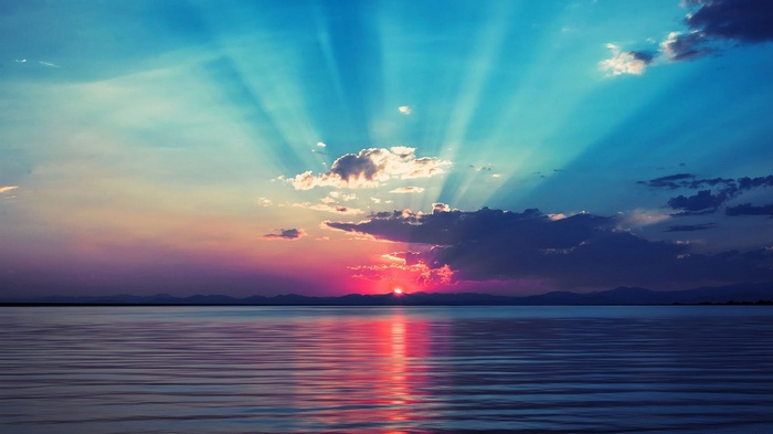 Sunset over the sea with sun rays