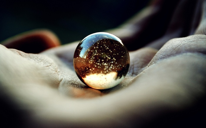 Glass marble with bubbles in a hand