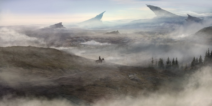 A lone rider on horseback in a misty valley with fantasy mountains