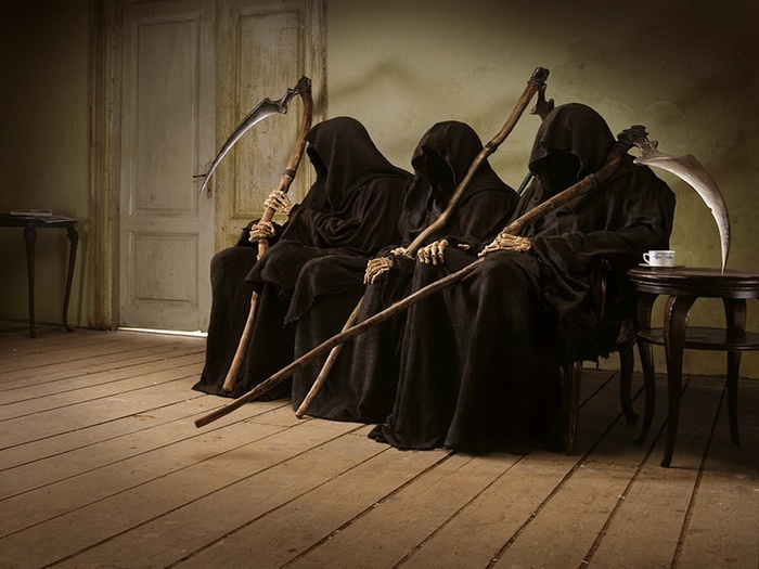 Four Grim Reapers with Scythes Sitting in a Room