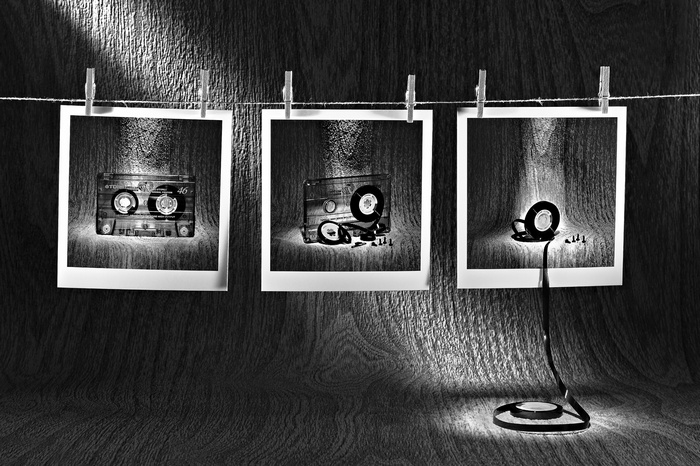 Monochrome Polaroids of Cassette Tape Components on Wood
