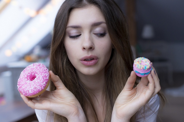 Klaudia Halejcio with a donut and a macaron