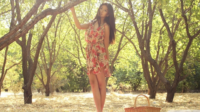 Asian woman in a floral dress in a forest
