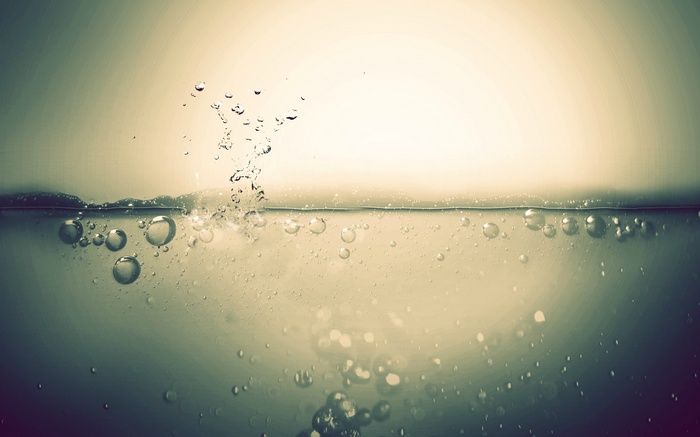 Bubbles rising in clear water with light background