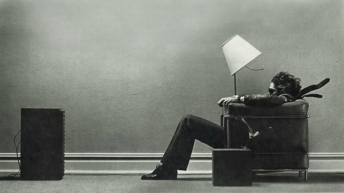 Man in armchair with lamp and speaker