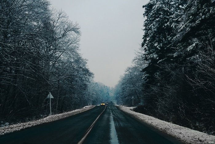 Winter road through a snow-covered forest