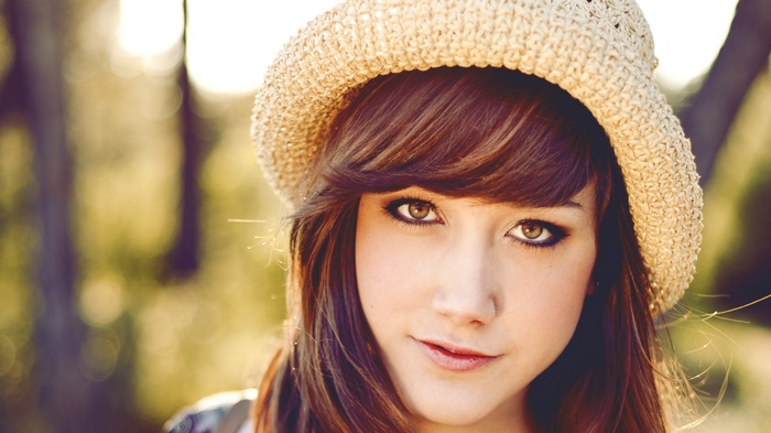 Woman wearing a straw hat in soft lighting