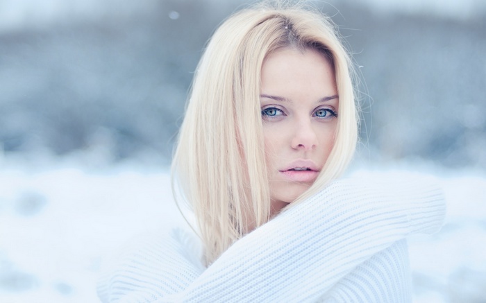 Blonde woman with blue eyes in the snow