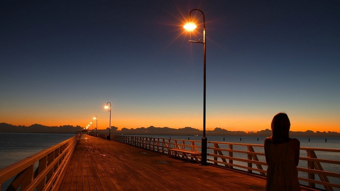 Person on a pier at sunset