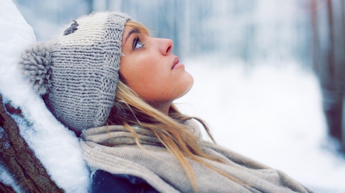 Woman in winter hat and scarf in snow