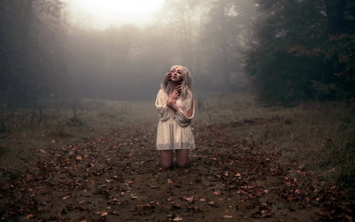 Woman in white dress in misty forest