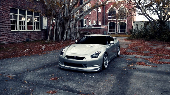 Silver Nissan GT-R parked near a brick building