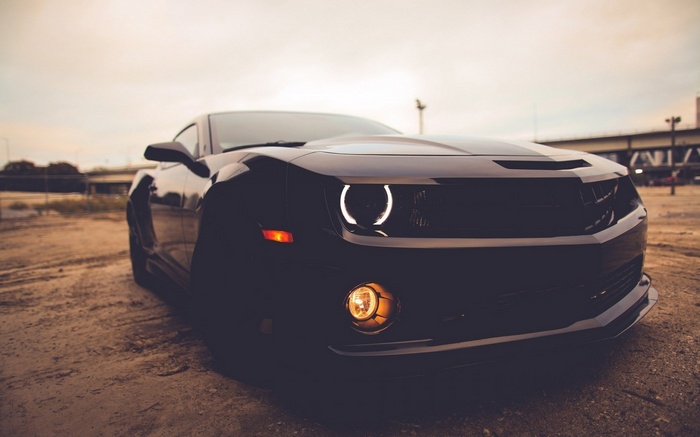Black Chevrolet Camaro parked on dirt road