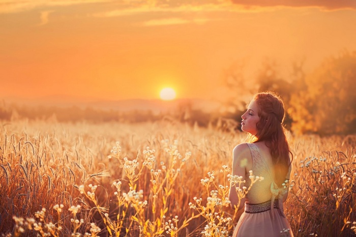 Woman in a field at sunset