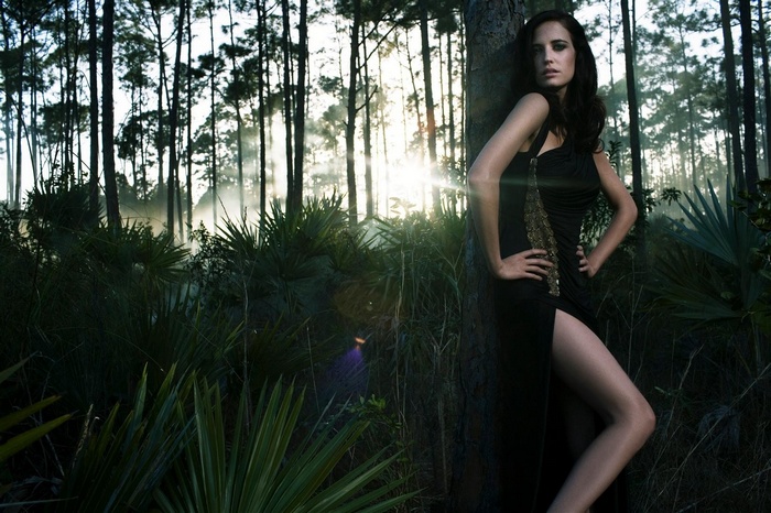 Eva Green in a black dress in a forest