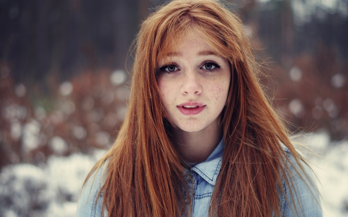 Young redhead woman with freckles in winter