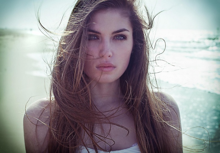 Woman with long brown hair on a beach