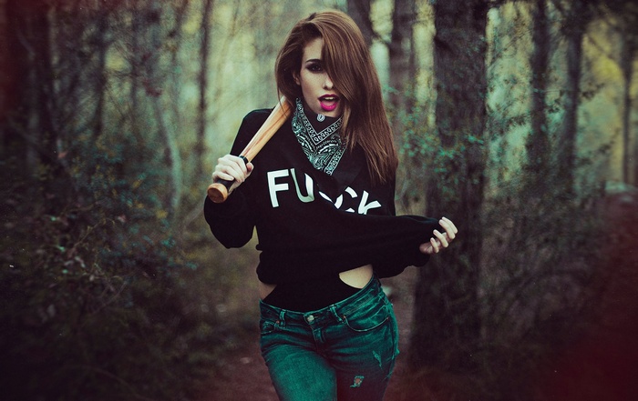 Woman with baseball bat in forest