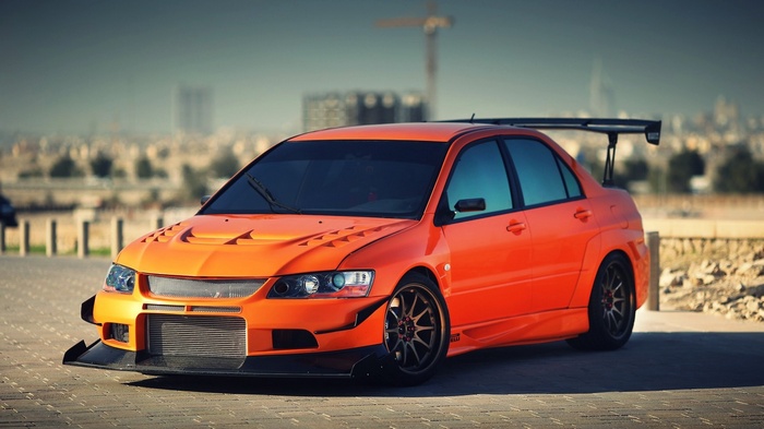 Orange Mitsubishi Lancer Evolution IX with a large spoiler