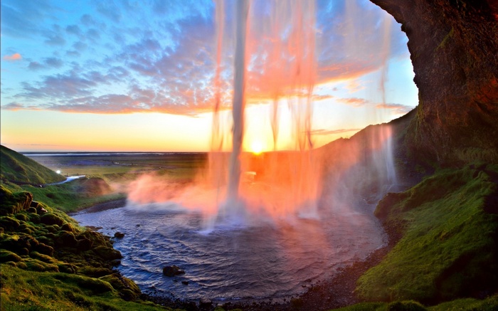 Waterfall at sunset with a rainbow mist