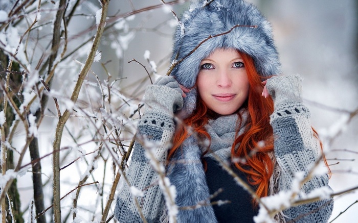 Woman in fur hat and gloves in snowy forest