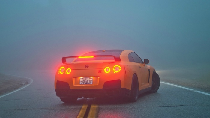 Orange Nissan GT-R on a foggy road