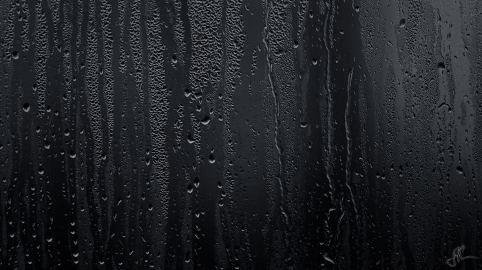 Raindrops on a dark, wet surface