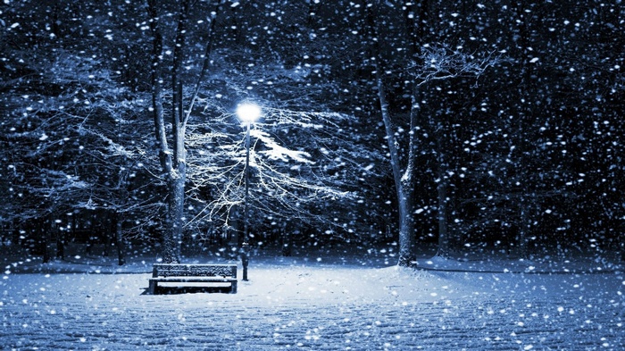 Snowy park with a bench and street light