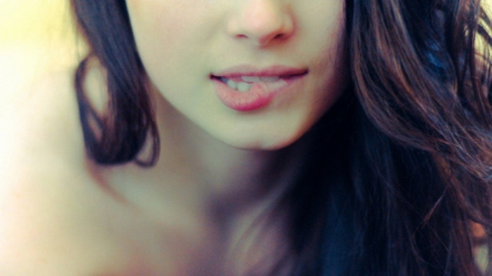 Woman biting her lip with long brunette hair