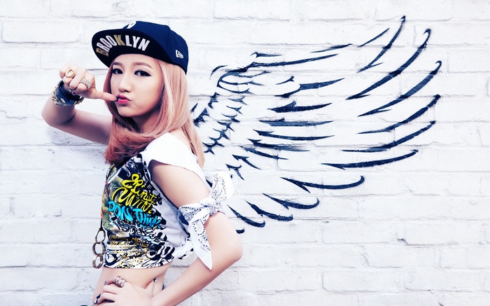 EvoL member Jucy with painted wings on a brick wall