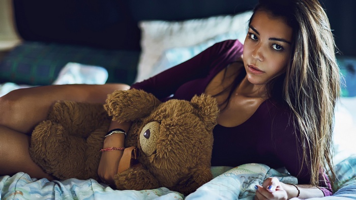 Woman with long hair holding a teddy bear