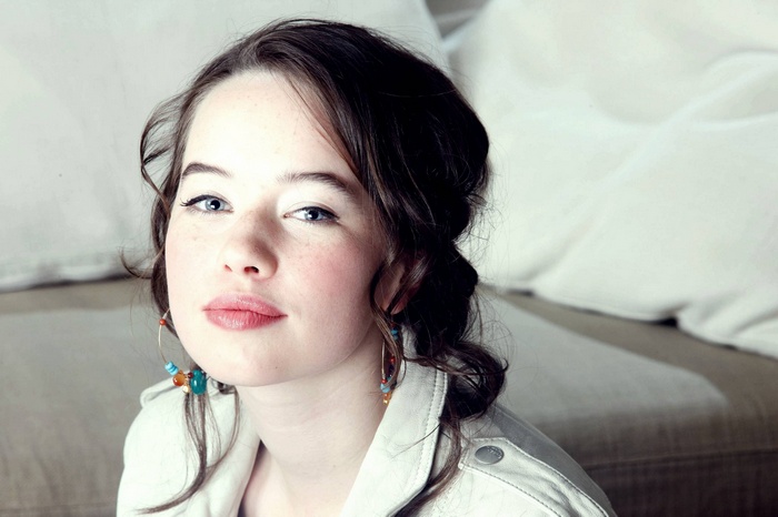 Anna Popplewell wearing a light jacket and earrings