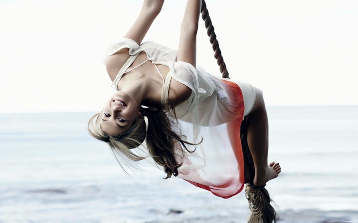 Woman hanging upside down on a rope swing