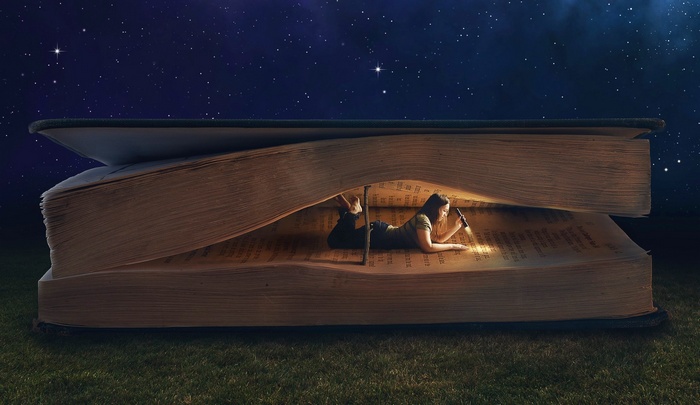 Woman reading a book under the stars