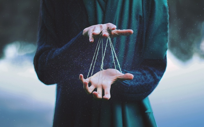 Hands controlling puppet strings