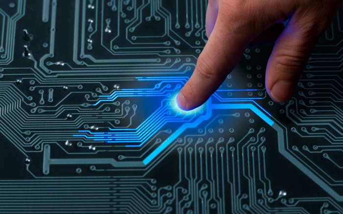 Finger touching glowing circuit board