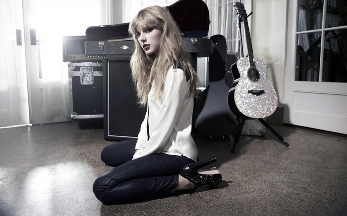 Taylor Swift with sparkly guitar and amps