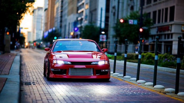 Red Nissan Silvia Spec-R driving on a city street
