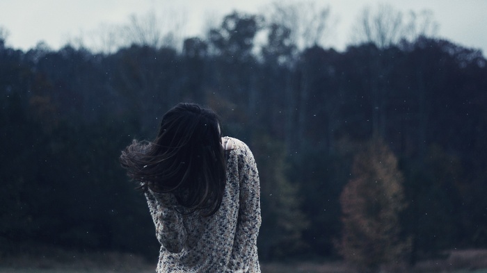 Woman in sweater standing outdoors in snow