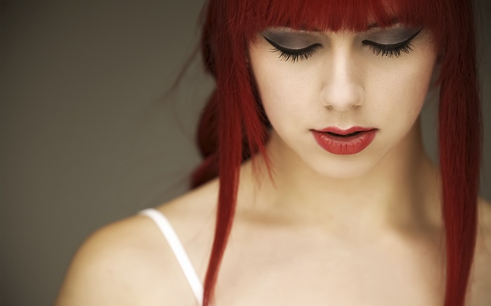Woman with red hair and dramatic makeup