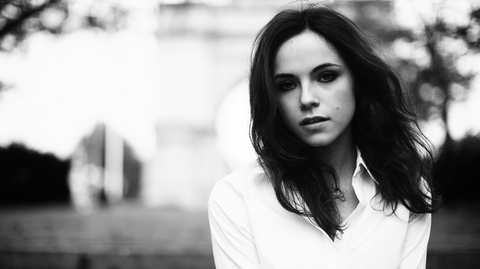 Woman with long dark hair wearing a white top