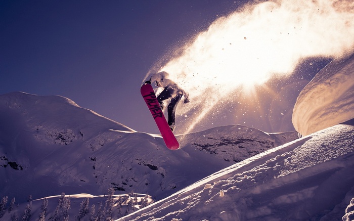 Snowboarder jumping in the air with snow spray