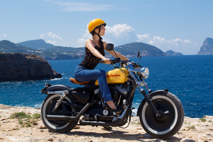 Woman in yellow helmet riding a yellow Harley Davidson motorcycle