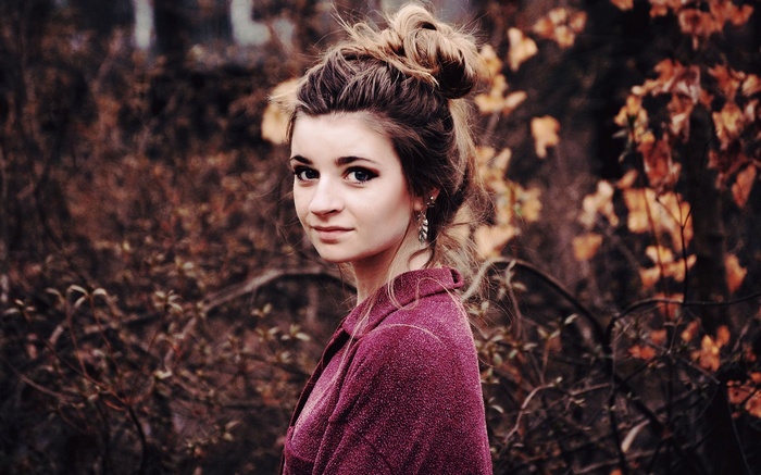 Woman with messy bun and purple jacket