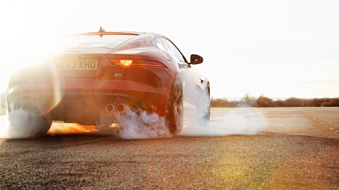 Jaguar F-Type performing a burnout on a road