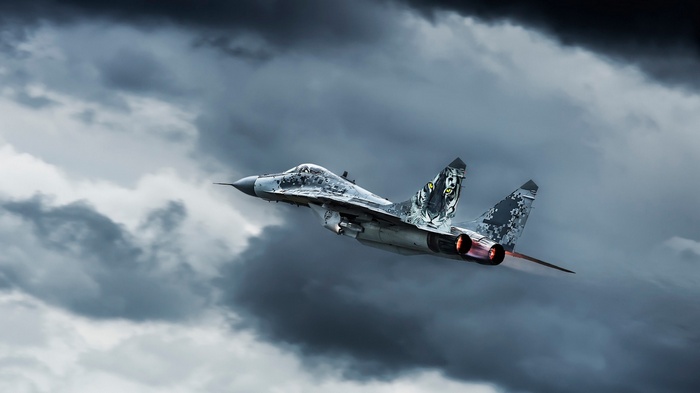 Mig-29 military aircraft flying through stormy clouds