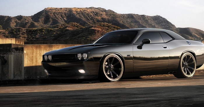 Black Dodge Challenger SRT parked near mountains