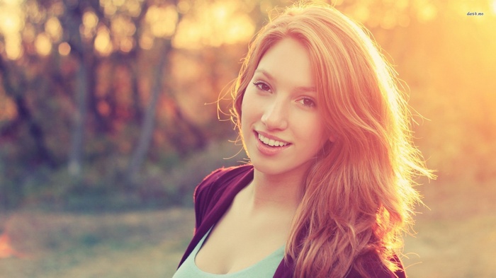 Young woman with blonde hair smiling outdoors