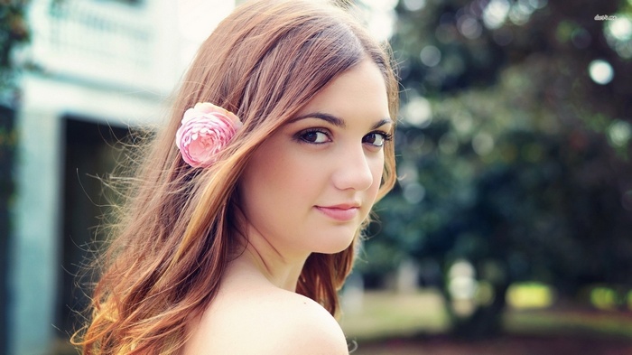 Young woman with a pink flower in her hair