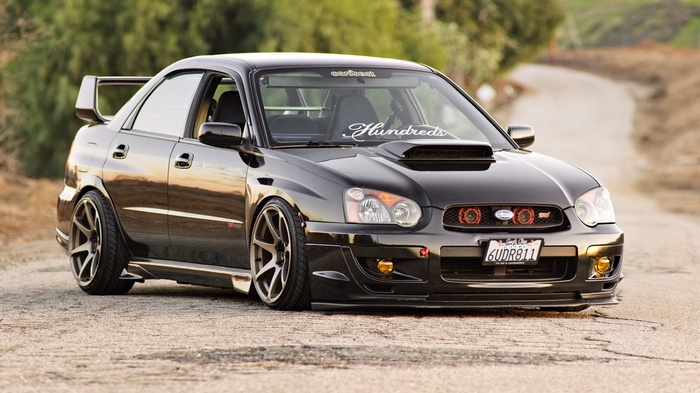 Black Subaru WRX STI parked on a dirt road